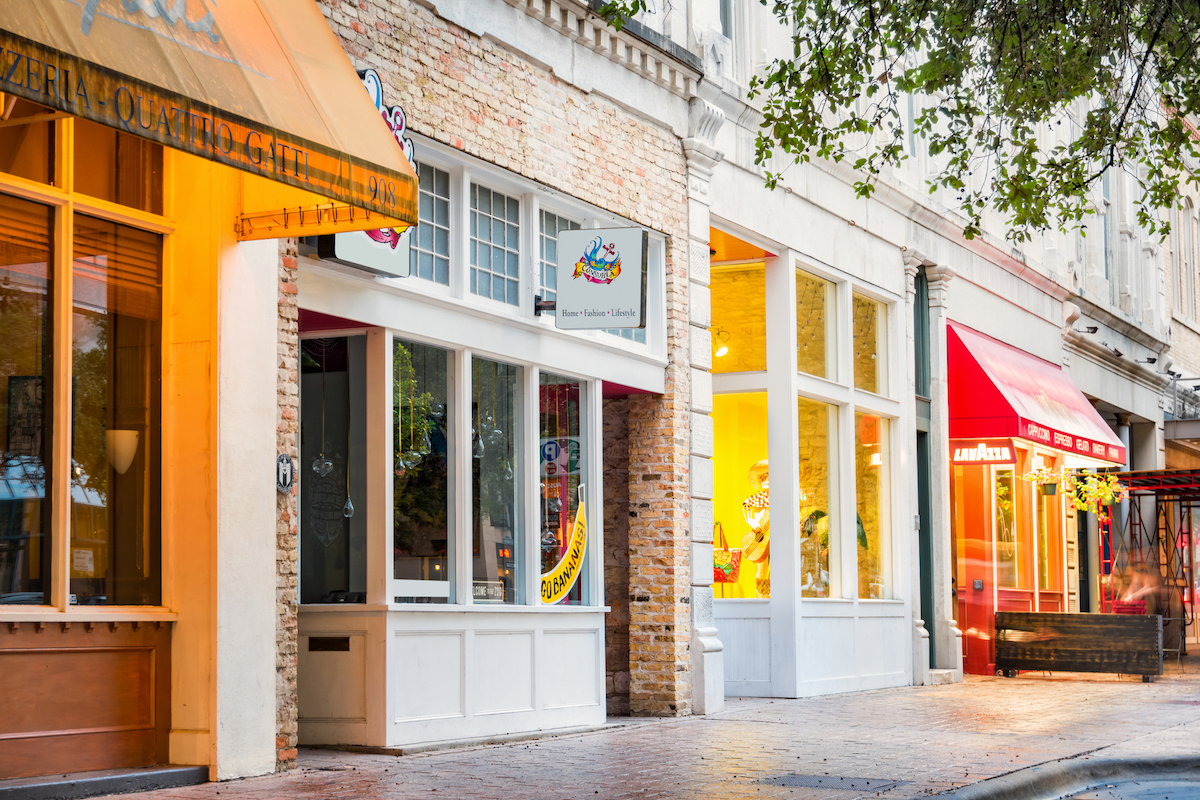 Photo of a row of illuminated, colorful shops, restaurants and businesses on Congress Avenue in Downtown Austin, Texas, USA.