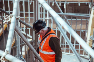 Older gentleman in construction gear at a construction site