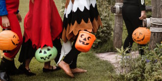 Group of children trick-or-treating walking up to a house to collect candy