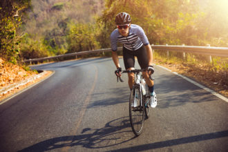 Man cycling in the morning on a forest road.