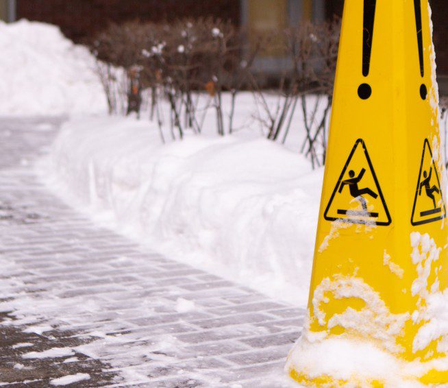 a yellow caution cone for slipping sits in the snow