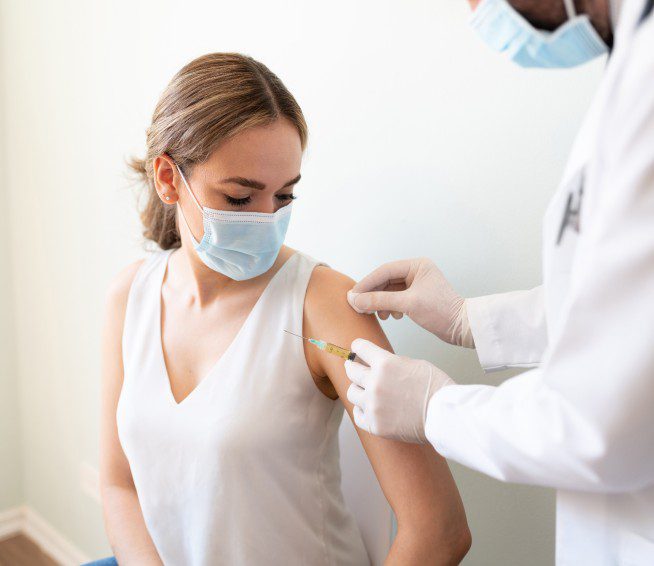 a doctor gives a woman a vaccine