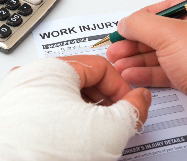 a man in a cast fills out a work injury report