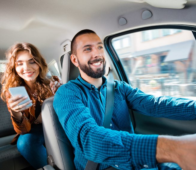 a woman on her phone speaks to the driver of the car they're in