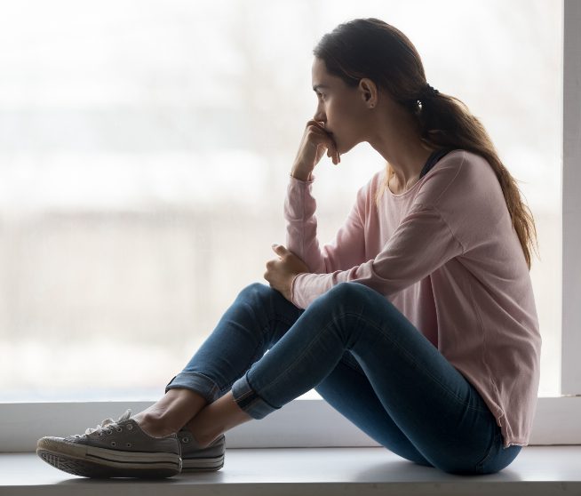 a woman stairs ponderously out of a window