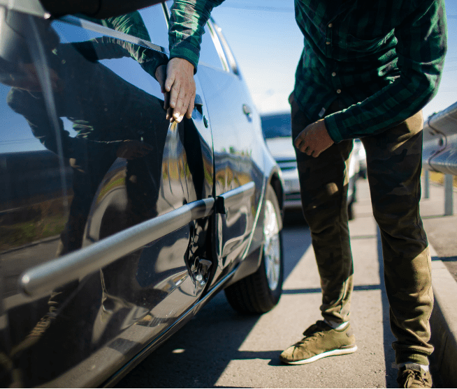 a man inspects a dent in his car