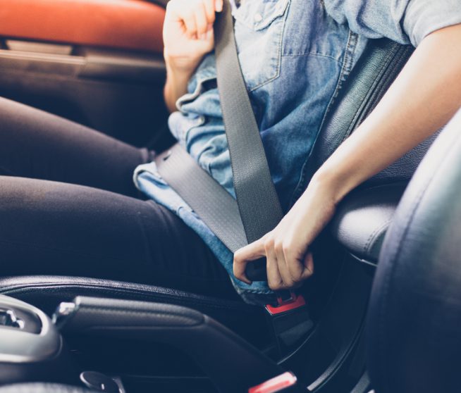 Man adjusting seatbelt in car