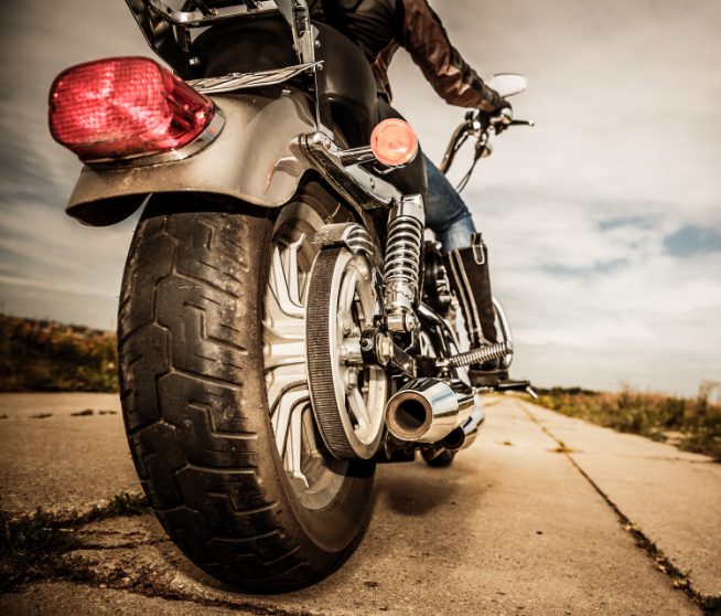 Person riding a motorcycle on the road while being prepared for the most common type of bike injury they may sustain while riding.