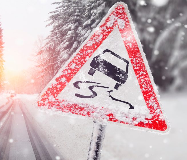 a slippery road sign covered in snow