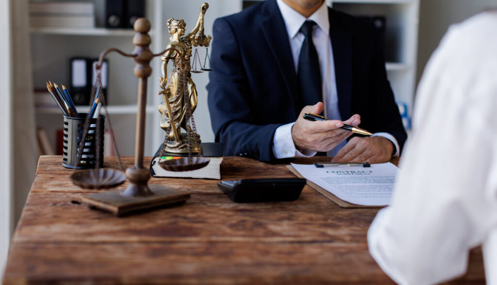 Two lawyers Consultation and conference discussing legal matters at a desk with a gavel, scales of justice law