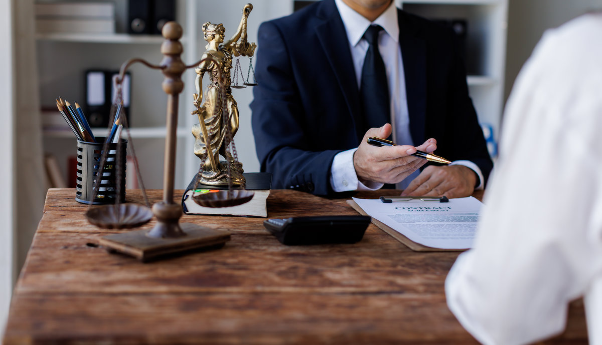 Two lawyers Consultation and conference discussing legal matters at a desk with a gavel, scales of justice law