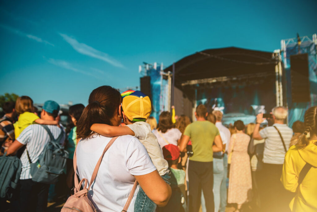 Mom with a baby in her arms at a street concert.