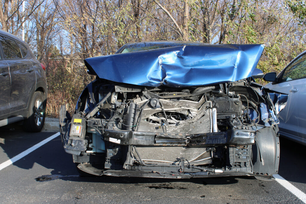Smashed blue car after a head-on collision