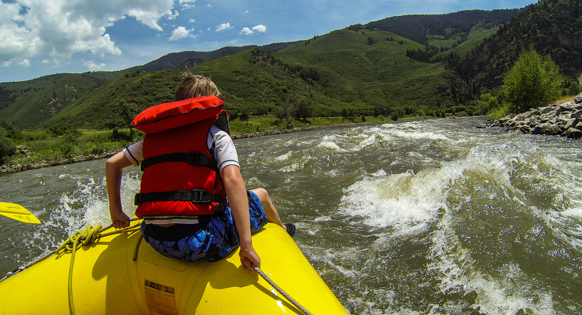 Young Boy rides the Bull during a white water rafting expedition in Glenwood Canyon on the Colorado River