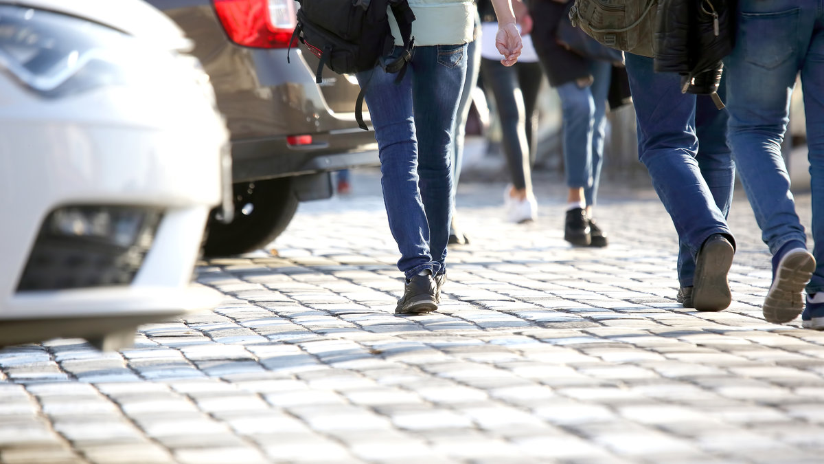 people cross the road in front of the car. transportation and pedestrian walkways
